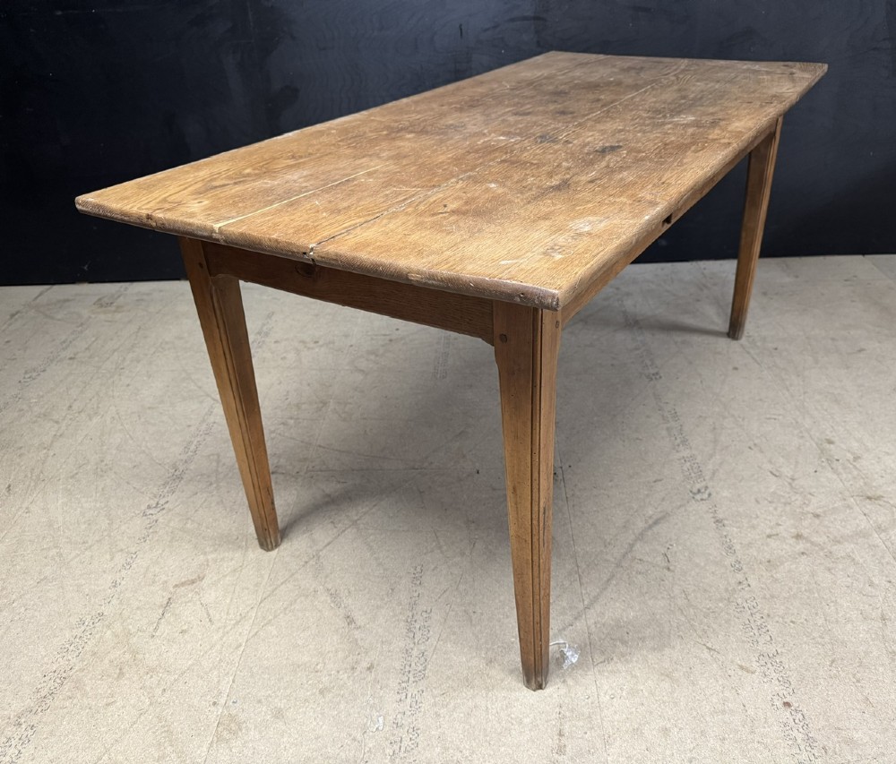 A rectangular natural oak French Normandy country table featuring a simple plank top, tapered legs, and a single frieze drawer. View IX