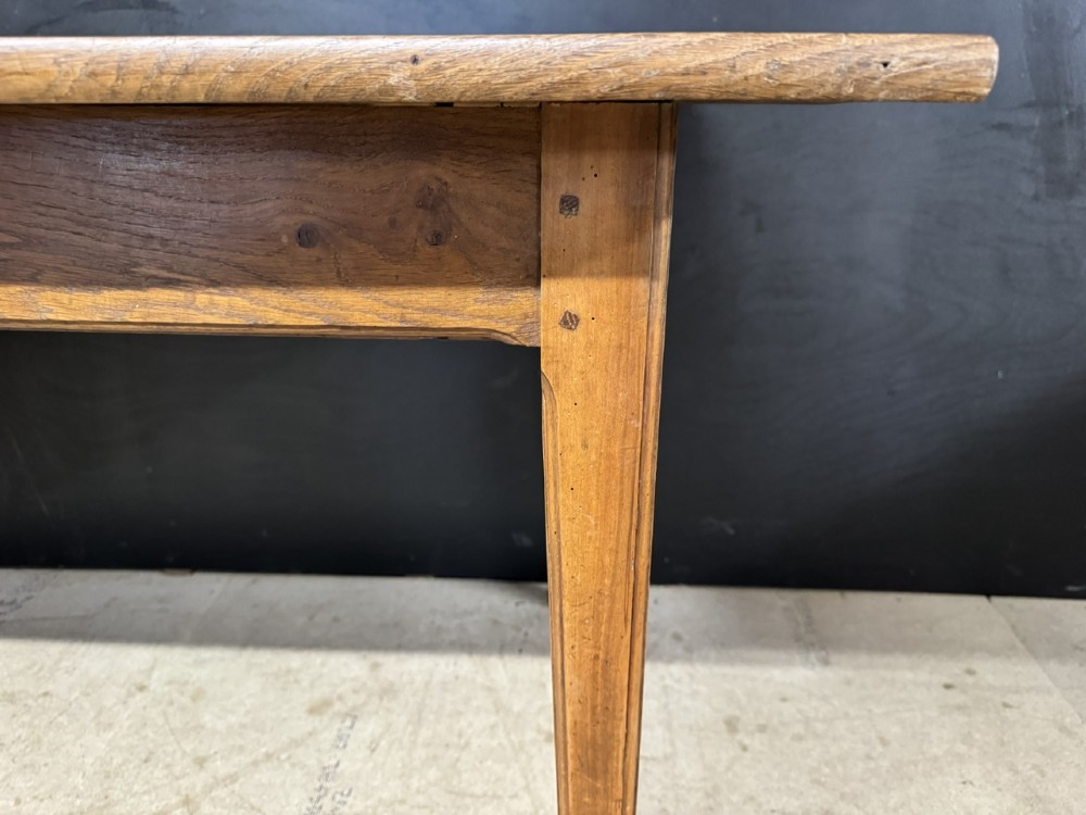 A rectangular natural oak French Normandy country table featuring a simple plank top, tapered legs, and a single frieze drawer. View XI