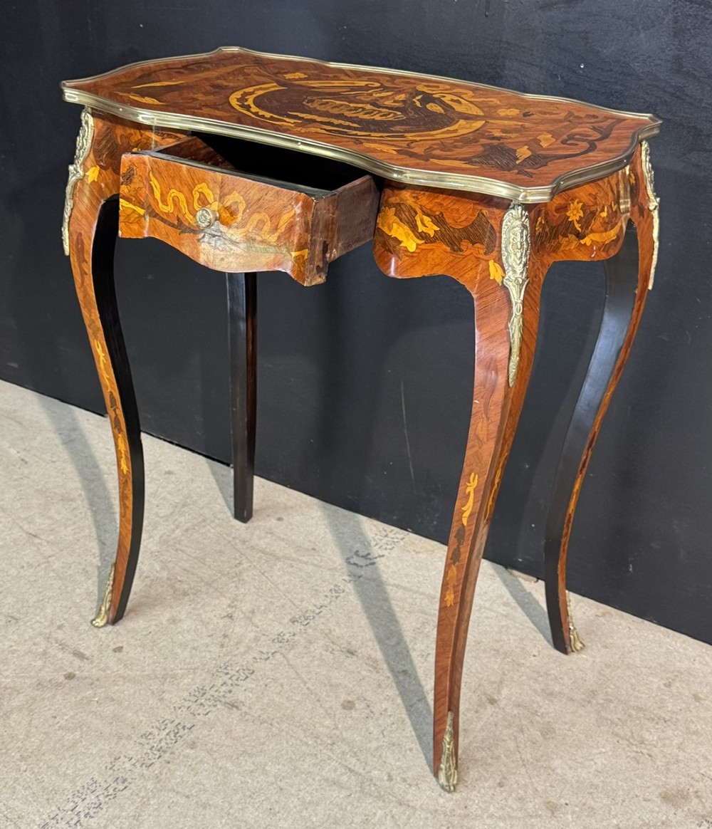 A French Louis XV style marquetry side table featuring cabriole legs, decorative brass mounts, and detailed floral wood inlay across the serpentine top and drawer. View V