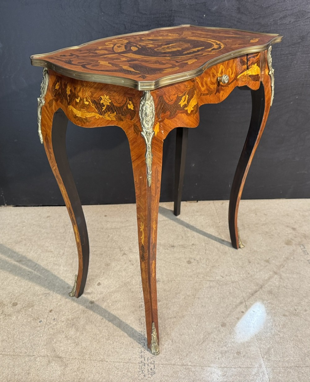 A French Louis XV style marquetry side table featuring cabriole legs, decorative brass mounts, and detailed floral wood inlay across the serpentine top and drawer. View VII