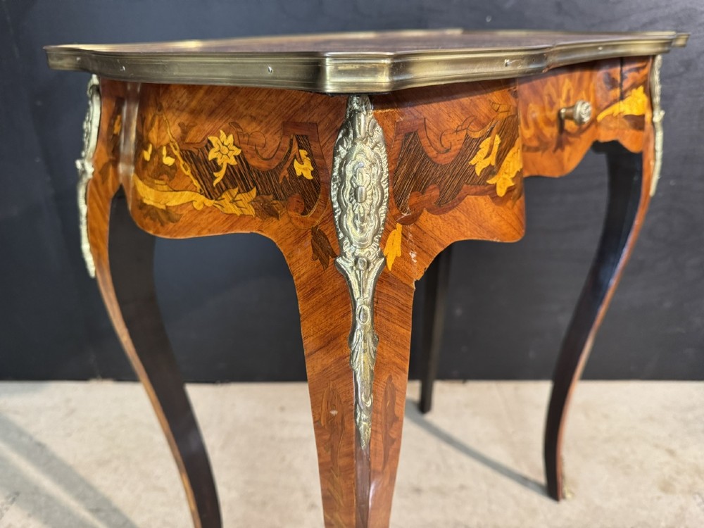 A French Louis XV style marquetry side table featuring cabriole legs, decorative brass mounts, and detailed floral wood inlay across the serpentine top and drawer. View VIII