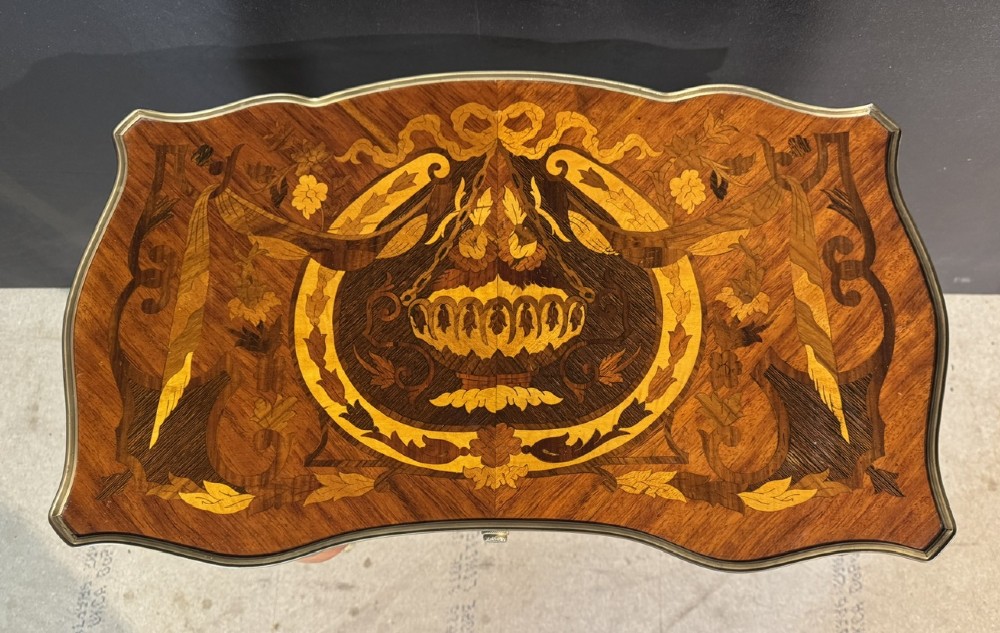 A French Louis XV style marquetry side table featuring cabriole legs, decorative brass mounts, and detailed floral wood inlay across the serpentine top and drawer. View IX