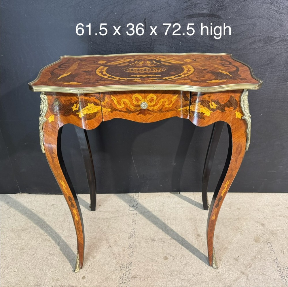 A French Louis XV style marquetry side table featuring cabriole legs, decorative brass mounts, and detailed floral wood inlay across the serpentine top and drawer. View XIV