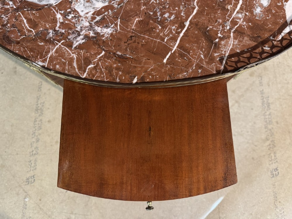 An oval French side table featuring a red veined marble top with a pierced brass gallery, geometric parquetry apron, and four tapered legs adorned with brass mounts. View VIII