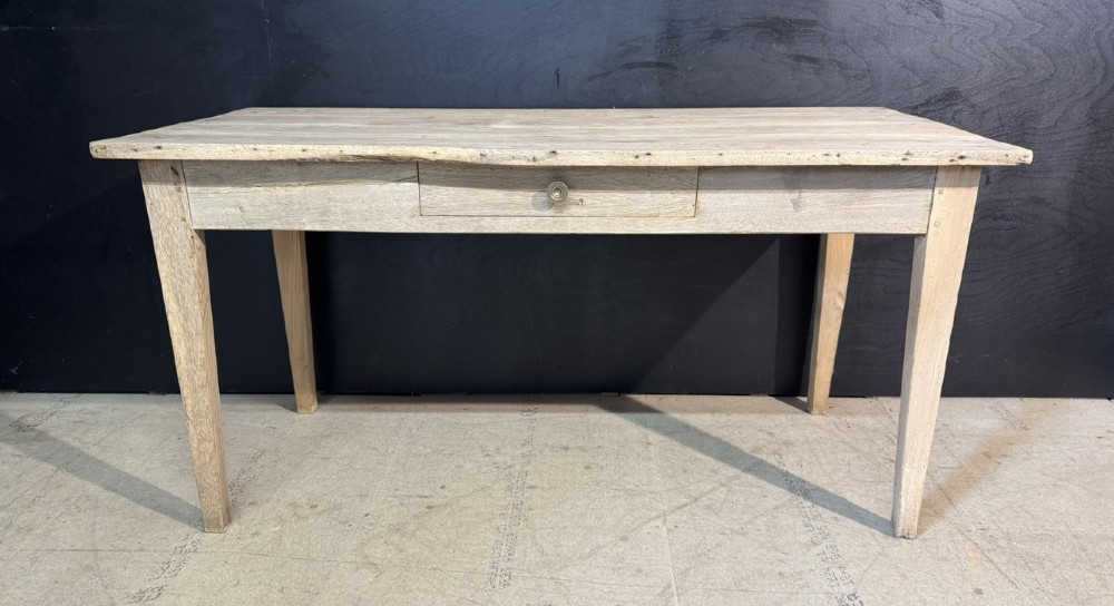 A rustic light oak French Normandy table featuring a flat plank top, a single central frieze drawer with a metal knob, and four square tapered legs. View II