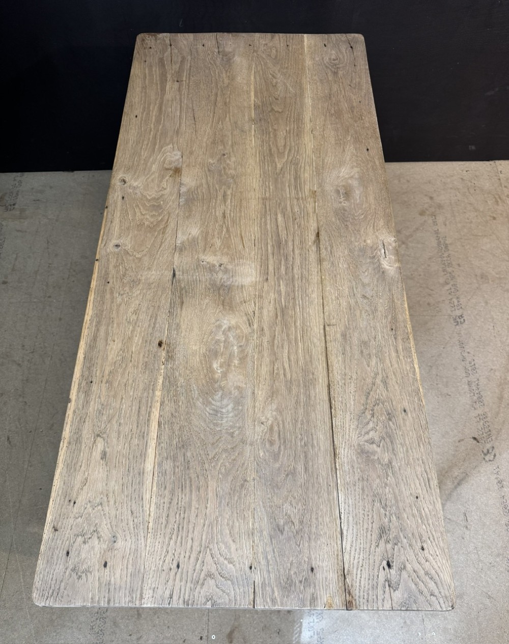 A rustic light oak French Normandy table featuring a flat plank top, a single central frieze drawer with a metal knob, and four square tapered legs. View VIII