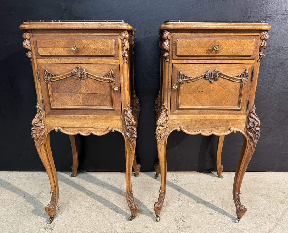 A pair of French walnut bedside cabinets with carved cabriole legs, dark marble tops, single drawers, and cupboard doors. View V