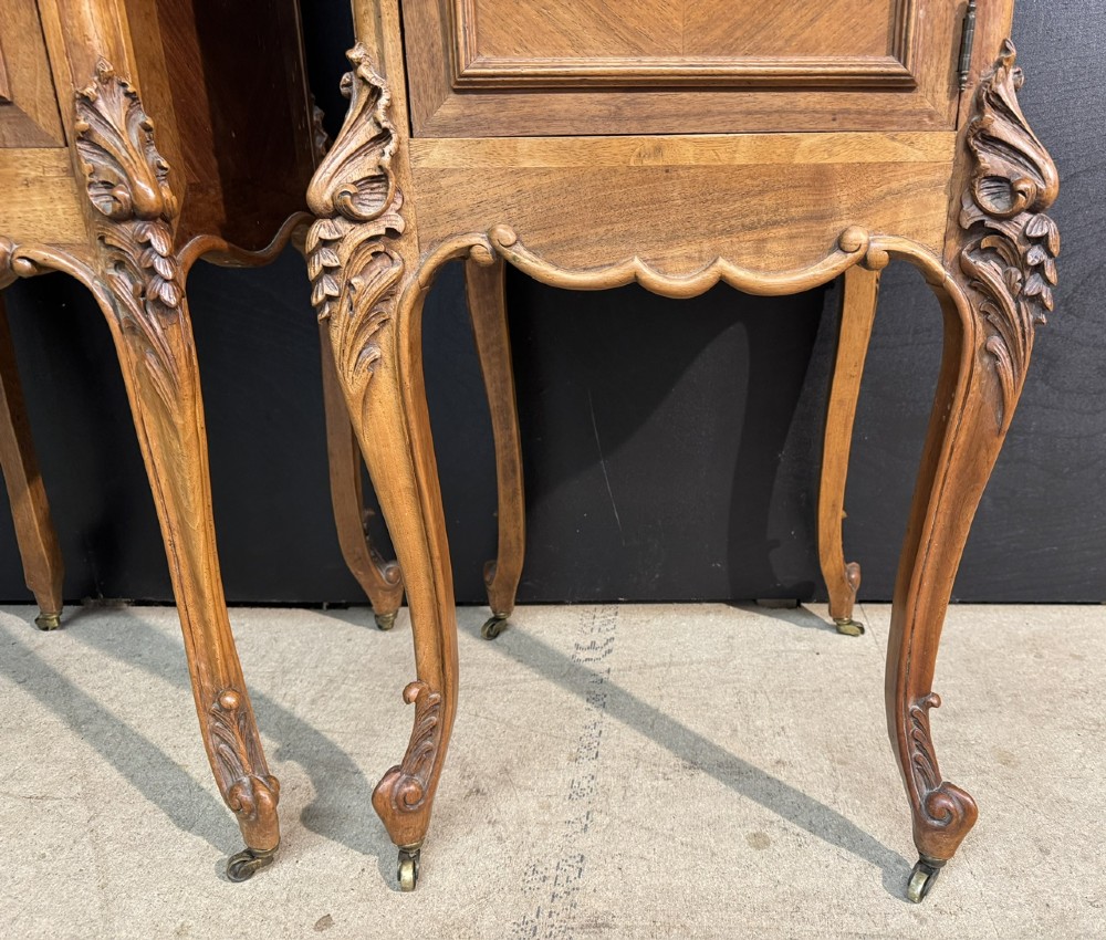 A pair of French walnut bedside cabinets with carved cabriole legs, dark marble tops, single drawers, and cupboard doors. View IX