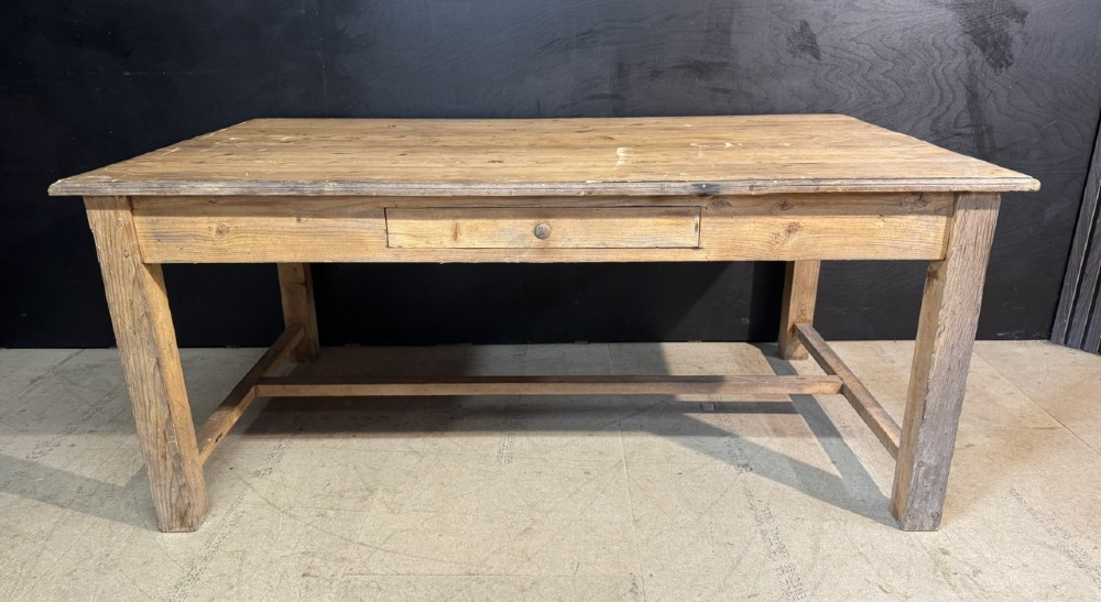 A rustic natural pine farmhouse kitchen table featuring a plank top, a single apron drawer, square legs, and a low stretcher base. View III