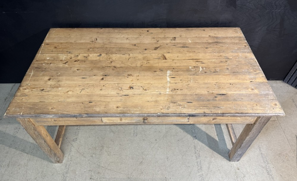 A rustic natural pine farmhouse kitchen table featuring a plank top, a single apron drawer, square legs, and a low stretcher base. View V