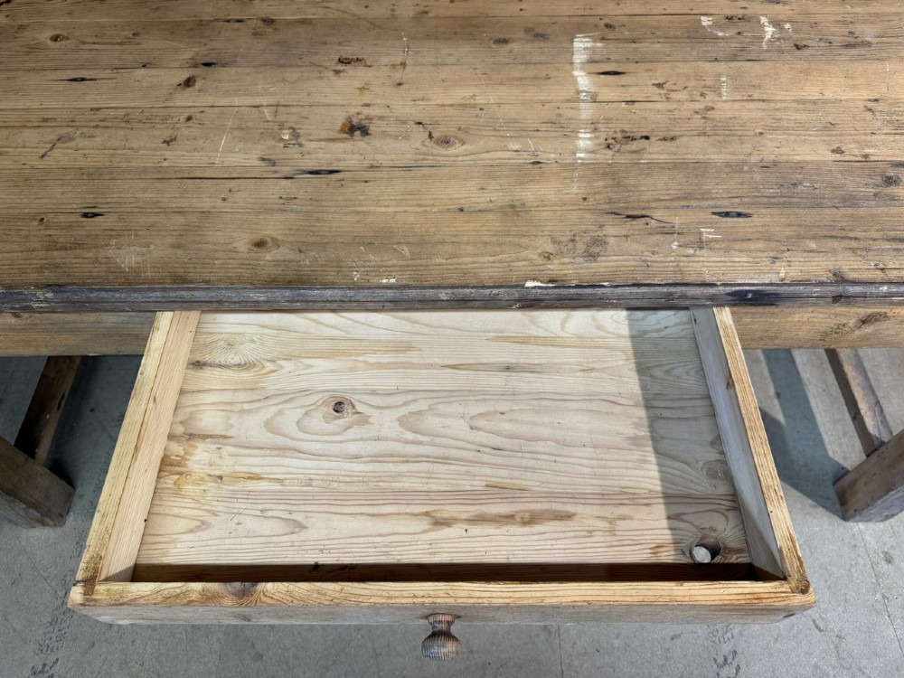 A rustic natural pine farmhouse kitchen table featuring a plank top, a single apron drawer, square legs, and a low stretcher base. View VIII