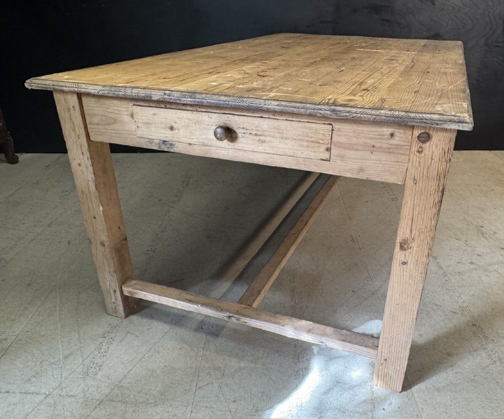 A rustic natural pine farmhouse kitchen table featuring a plank top, a single apron drawer, square legs, and a low stretcher base. View X