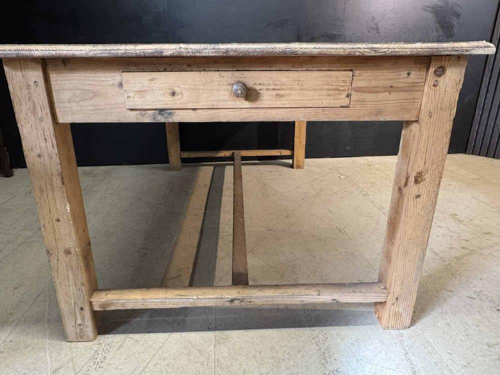A rustic natural pine farmhouse kitchen table featuring a plank top, a single apron drawer, square legs, and a low stretcher base. View XII