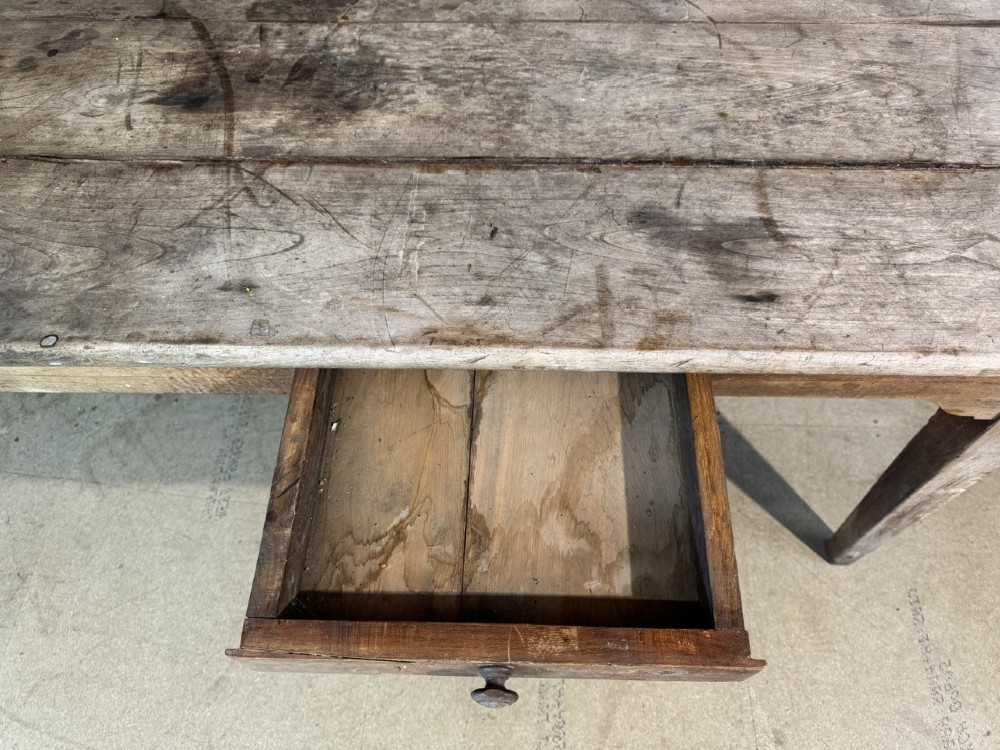 A rustic French provincial kitchen table featuring a scrubbed timber plank top, a single frieze drawer with a small knob, and four tapered square legs. View V