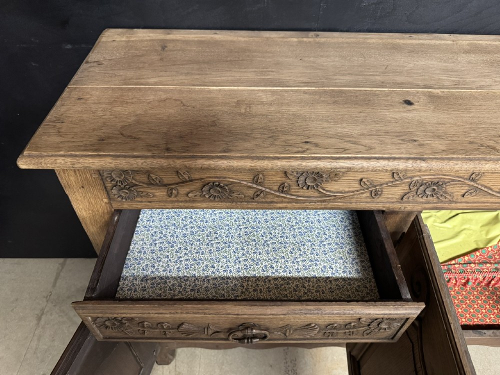 A long French oak enfilade featuring four cupboards with arched fielded panels, decorative floral carvings along the frieze, and two side drawers. View VI