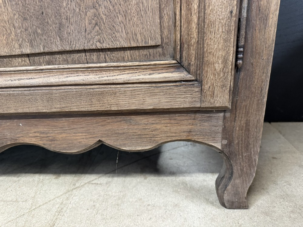A long French oak enfilade featuring four cupboards with arched fielded panels, decorative floral carvings along the frieze, and two side drawers. View IX