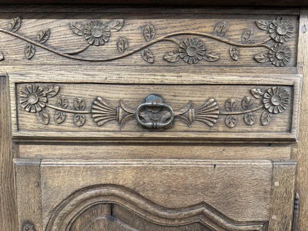 A long French oak enfilade featuring four cupboards with arched fielded panels, decorative floral carvings along the frieze, and two side drawers. View X