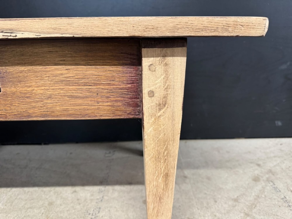 A low French oak coffee table with a rectangular light wood plank top, a single frieze drawer, and tapered square legs. View V