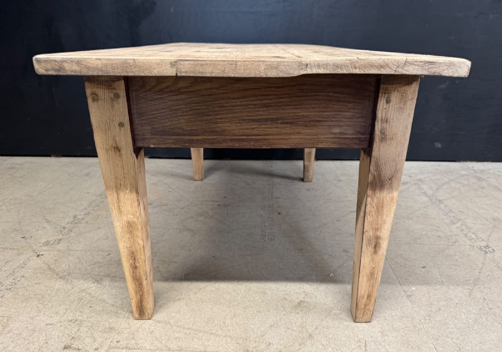 A low French oak coffee table with a rectangular light wood plank top, a single frieze drawer, and tapered square legs. View VII
