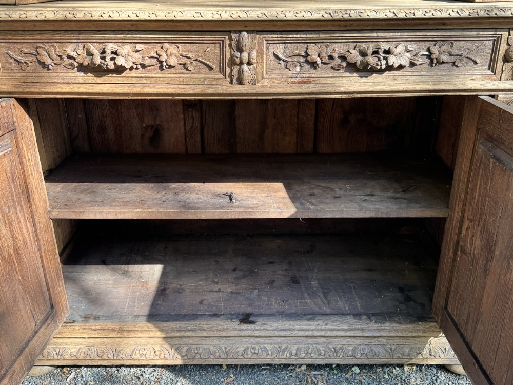 A two-piece bleached oak hunting cabinet featuring hand-carved relief panels of game birds, glazed upper doors, and a decorative mask pediment. View VIII