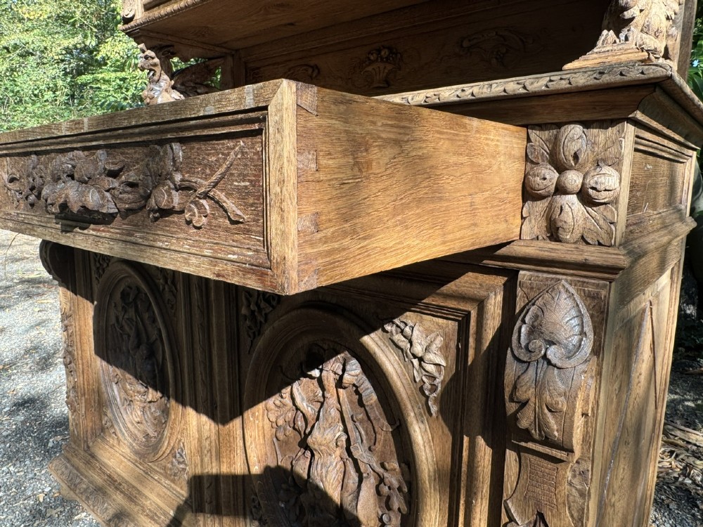 A two-piece bleached oak hunting cabinet featuring hand-carved relief panels of game birds, glazed upper doors, and a decorative mask pediment. View XII