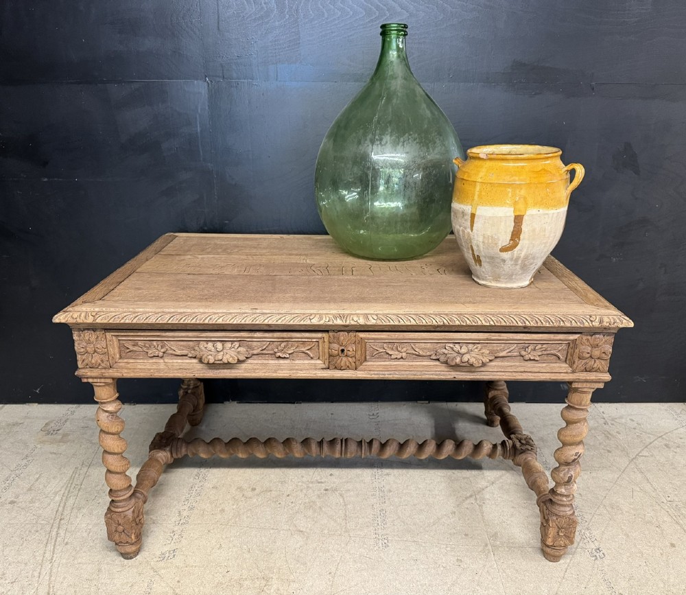 A French bleached oak writing desk featuring hand-carved floral drawer fronts, egg-and-dart moulding, turned barley twist legs, and an H-stretcher base. View II