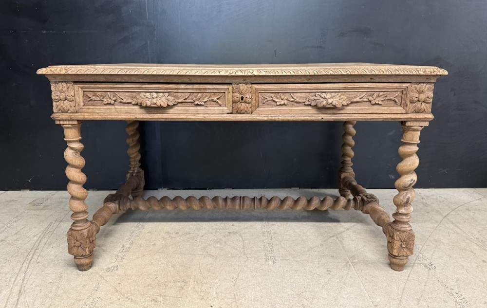 A French bleached oak writing desk featuring hand-carved floral drawer fronts, egg-and-dart moulding, turned barley twist legs, and an H-stretcher base. View III