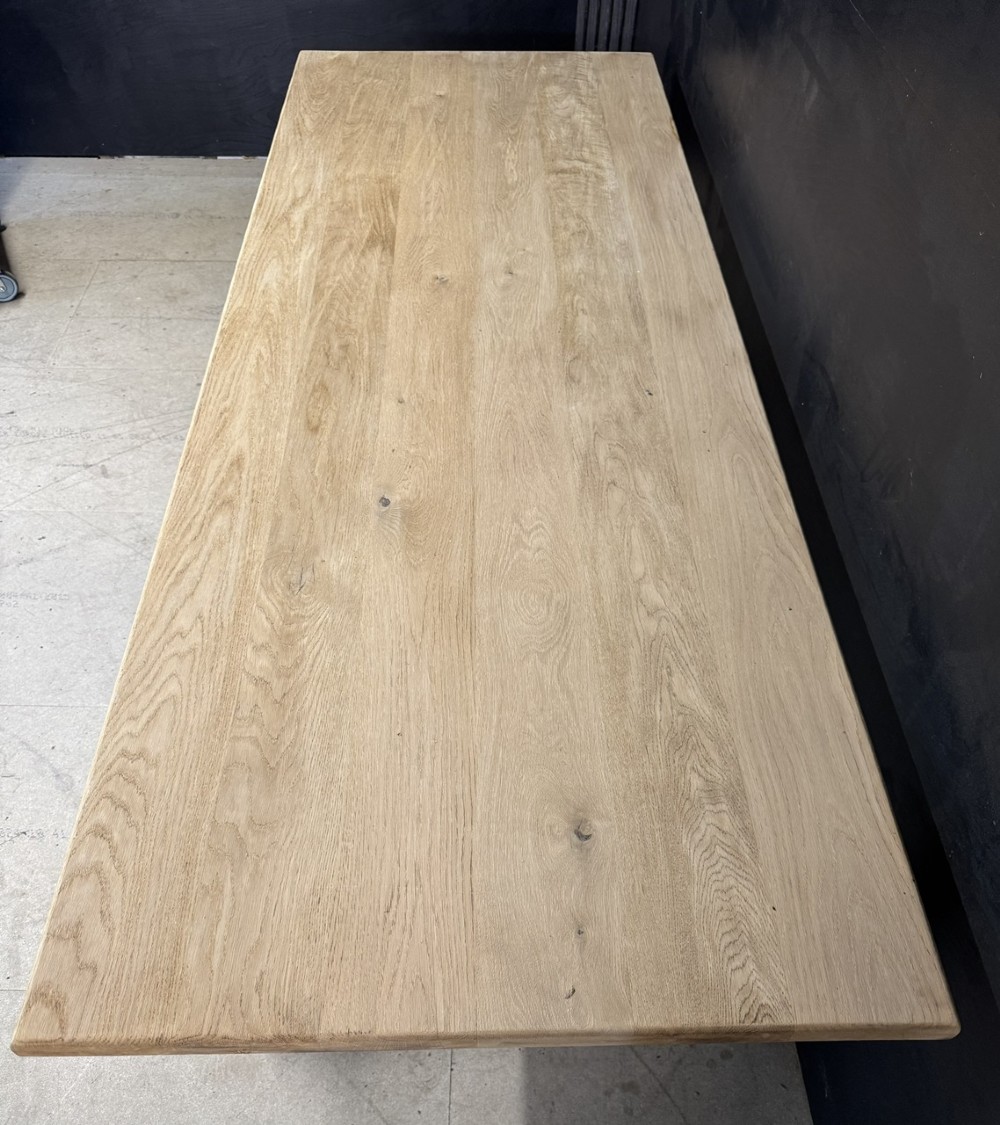 A large light oak farmhouse dining table featuring a solid plank top, turned legs, and an H-shaped stretcher base. View VI