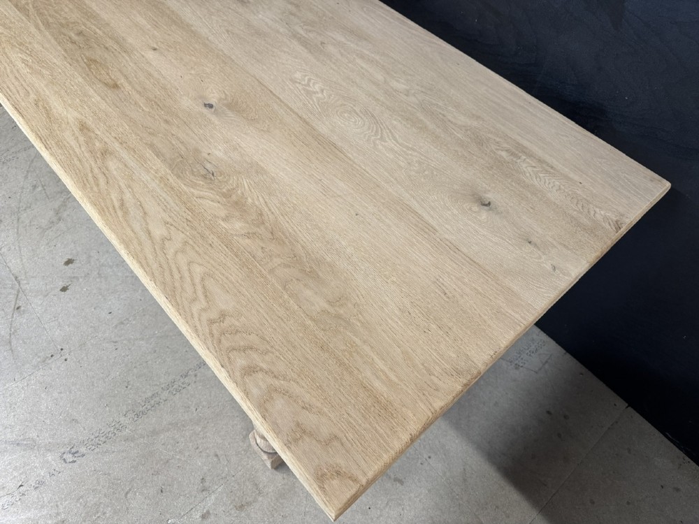 A large light oak farmhouse dining table featuring a solid plank top, turned legs, and an H-shaped stretcher base. View VII