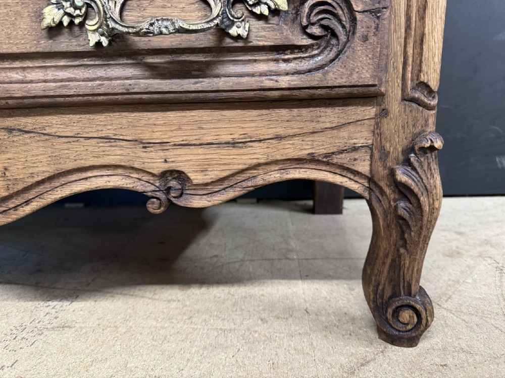 A French provincial bleached oak commode featuring three drawers with carved decorative mouldings and cast metal handles. View VI