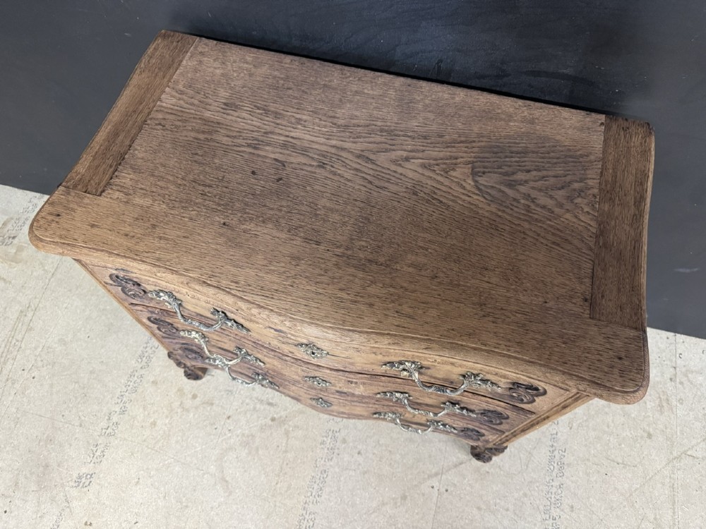 A French provincial bleached oak commode featuring three drawers with carved decorative mouldings and cast metal handles. View VII