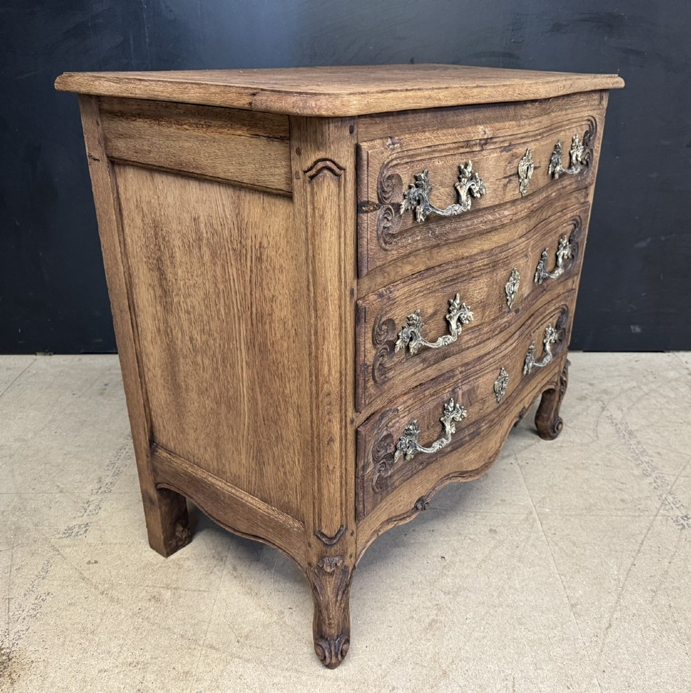 A French provincial bleached oak commode featuring three drawers with carved decorative mouldings and cast metal handles. View VIII