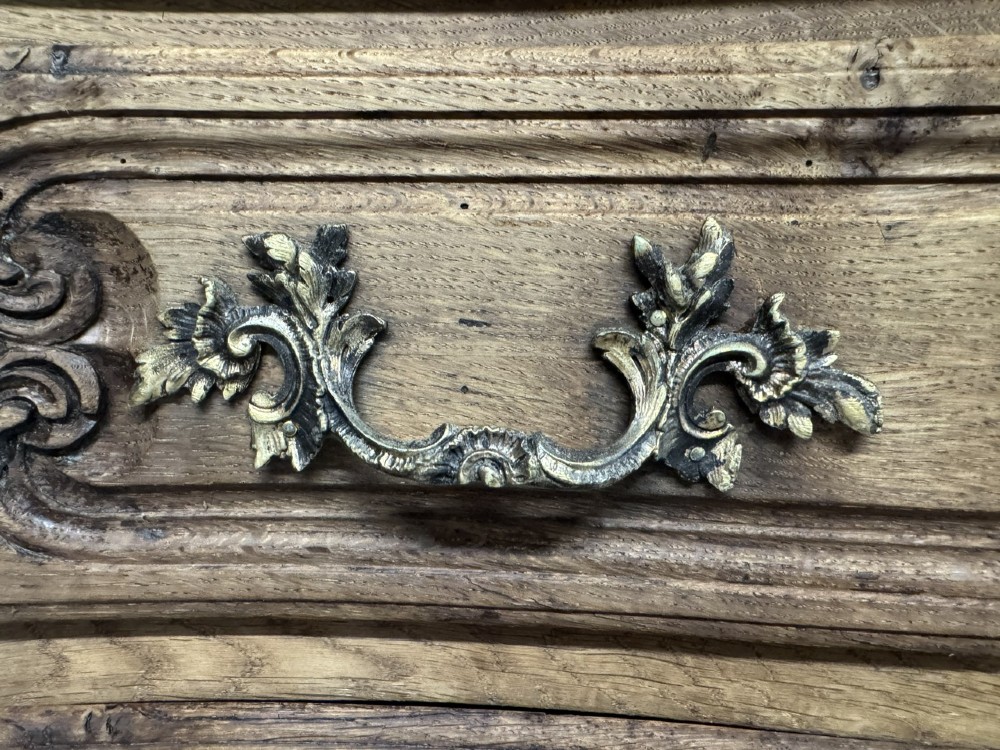A French provincial bleached oak commode featuring three drawers with carved decorative mouldings and cast metal handles. View XI