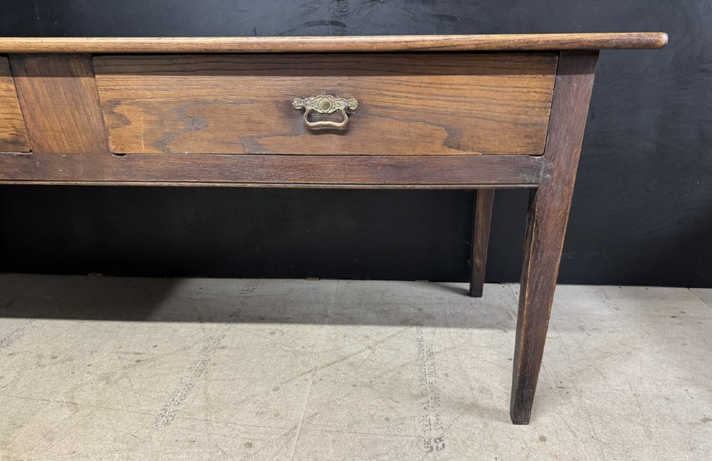 A rectangular antique French chestnut console prep table featuring two drawers with brass drop handles and square tapered legs. View IV