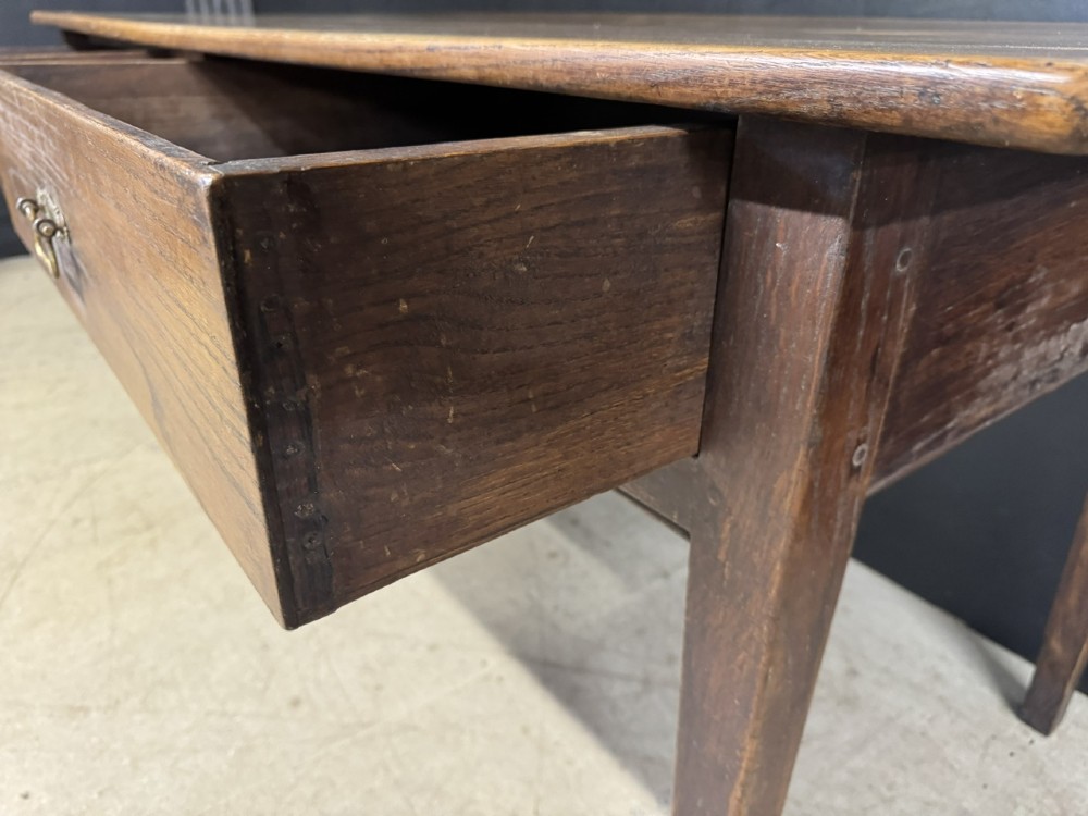 A rectangular antique French chestnut console prep table featuring two drawers with brass drop handles and square tapered legs. View X