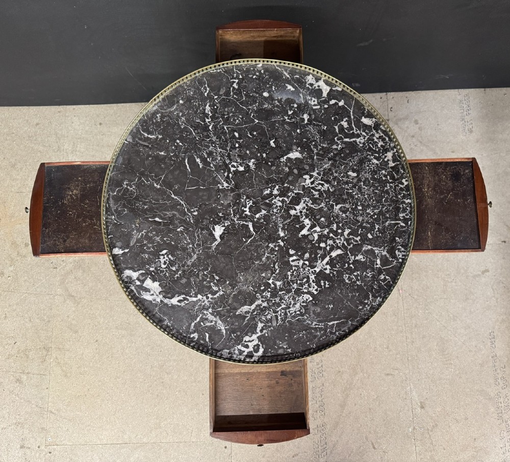 A circular French Louis XVI style lamp table featuring a dark veined marble top, a pierced brass gallery rim, a single drawer, and four square tapered legs. View V