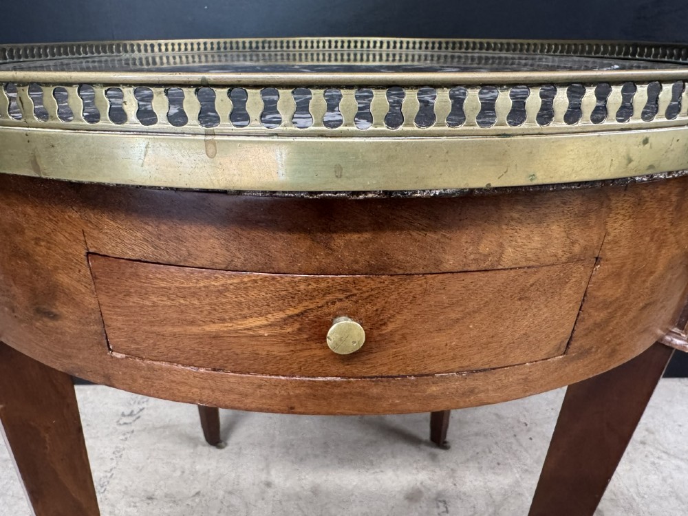 A circular French Louis XVI style lamp table featuring a dark veined marble top, a pierced brass gallery rim, a single drawer, and four square tapered legs. View VIII