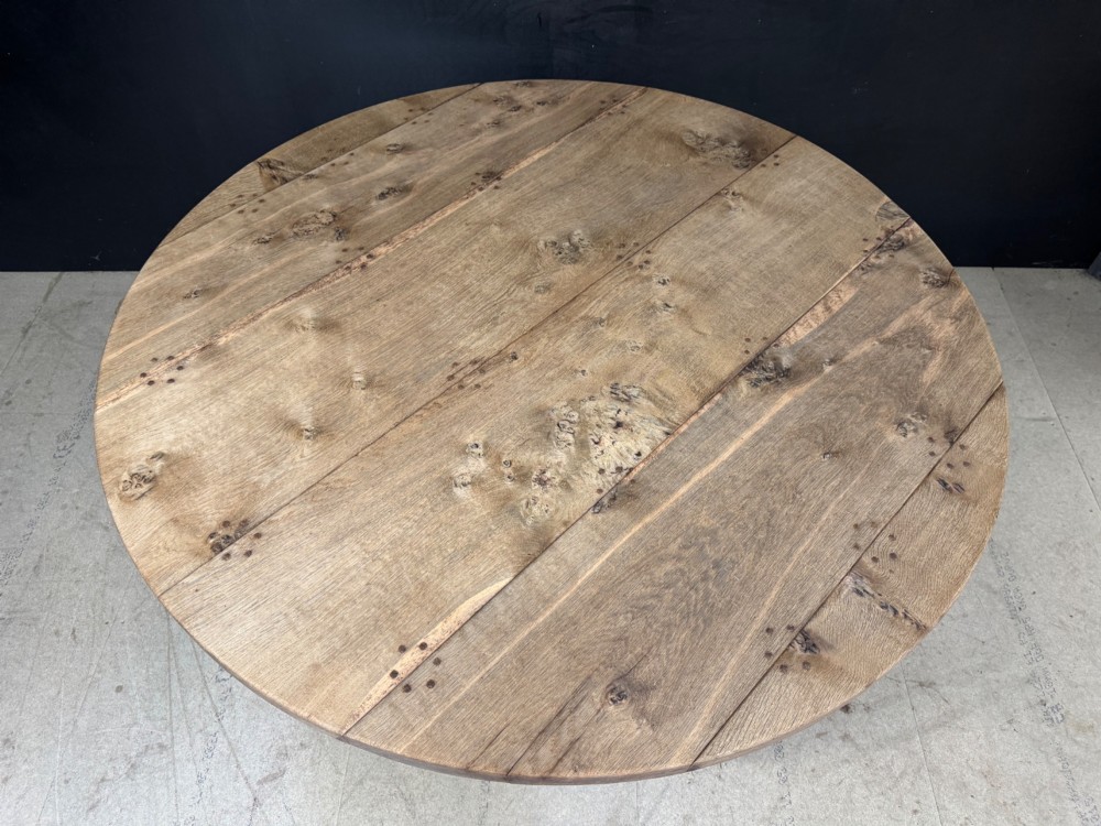 A large round oak dining table featuring a planked top and a substantial wooden cross-pedestal base. View III