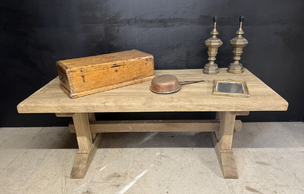A solid bleached oak dining table featuring a thick rectangular top supported by a sturdy trestle base and central stretcher rail. View II