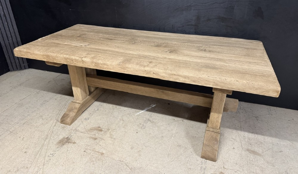 A solid bleached oak dining table featuring a thick rectangular top supported by a sturdy trestle base and central stretcher rail. View III