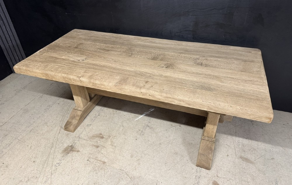 A solid bleached oak dining table featuring a thick rectangular top supported by a sturdy trestle base and central stretcher rail. View IV