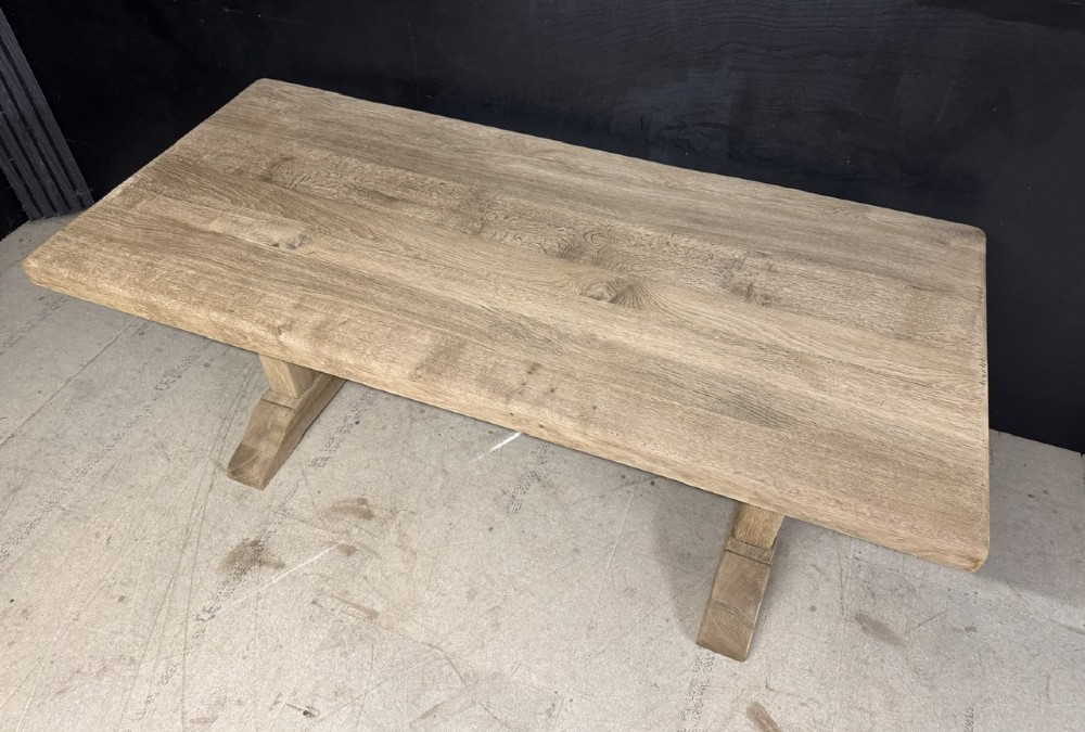 A solid bleached oak dining table featuring a thick rectangular top supported by a sturdy trestle base and central stretcher rail. View VIII