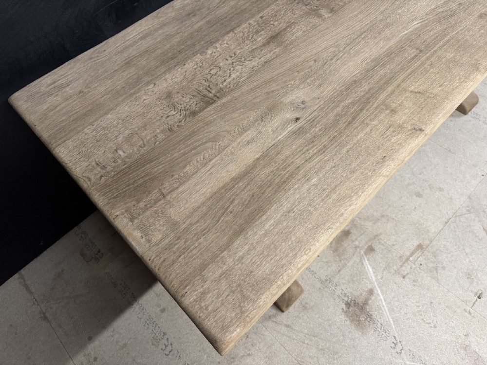 A solid bleached oak dining table featuring a thick rectangular top supported by a sturdy trestle base and central stretcher rail. View XI