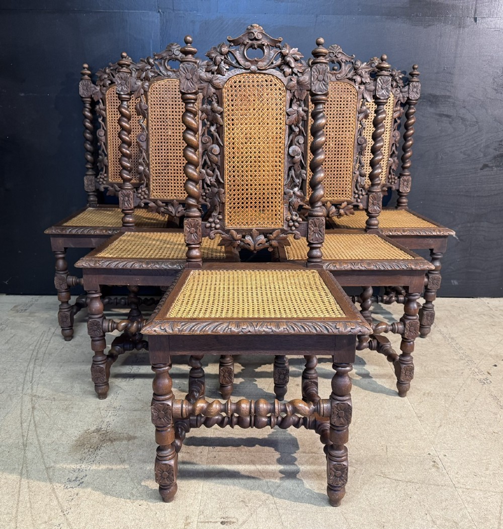 A set of six dark oak dining chairs with carved crestings, barley twist supports, and woven cane panels. View II