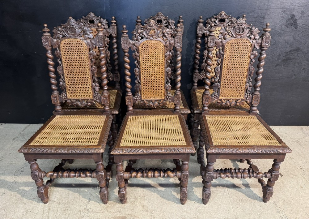 A set of six dark oak dining chairs with carved crestings, barley twist supports, and woven cane panels. View IV