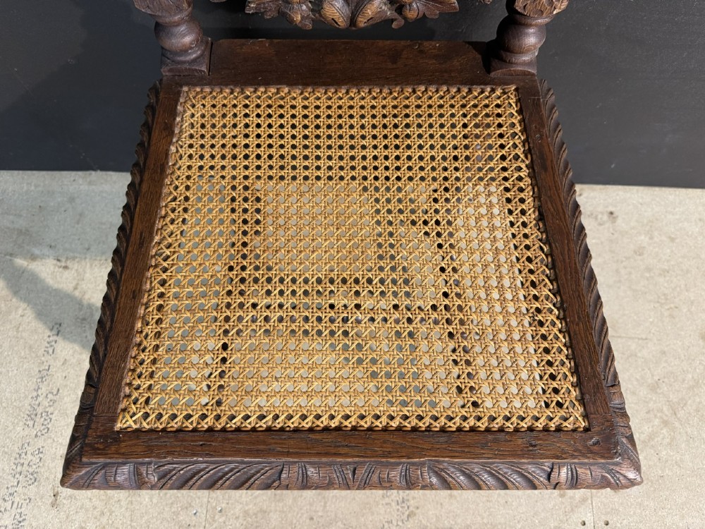 A set of six dark oak dining chairs with carved crestings, barley twist supports, and woven cane panels. View IX