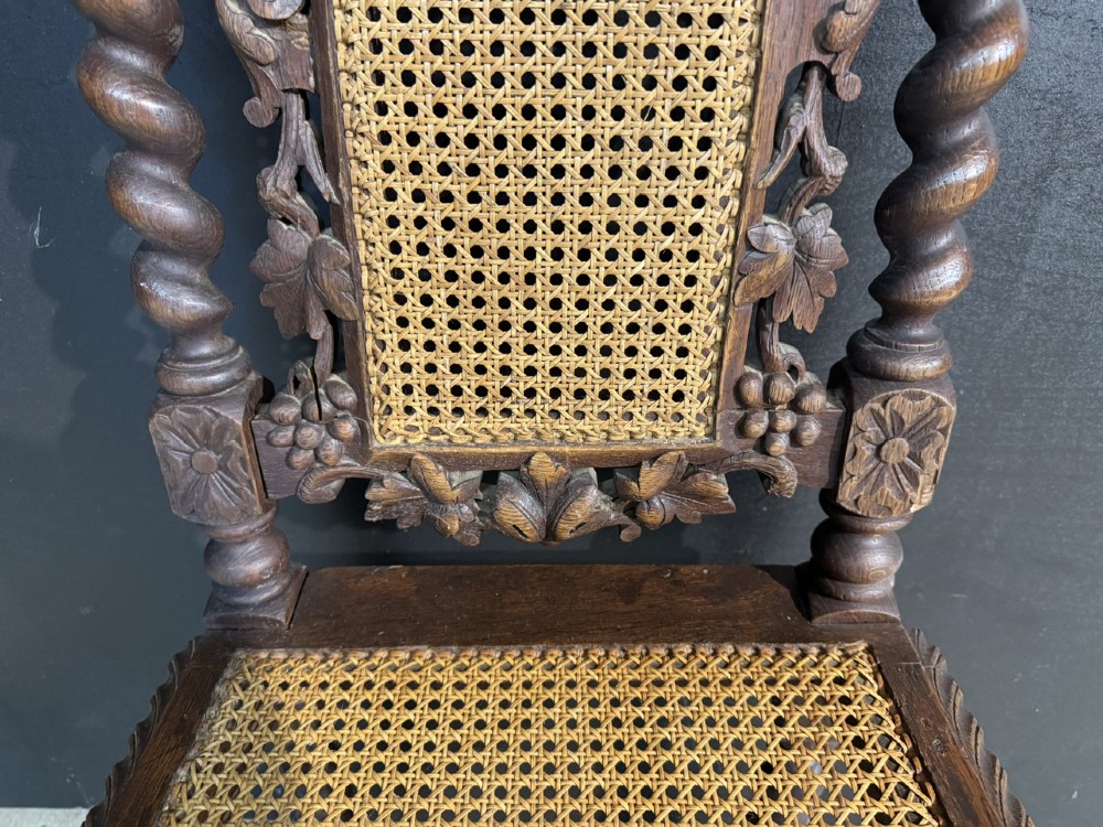 A set of six dark oak dining chairs with carved crestings, barley twist supports, and woven cane panels. View XI