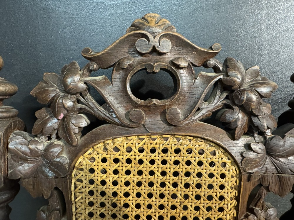 A set of six dark oak dining chairs with carved crestings, barley twist supports, and woven cane panels. View XIII
