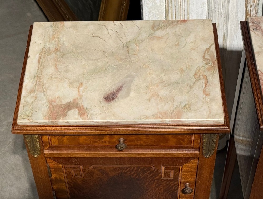 A pair of French Louis XVI style wooden bedside cabinets featuring marble tops, single drawers, inlaid cupboard doors, and gilt brass mounts on slender tapered legs. View III
