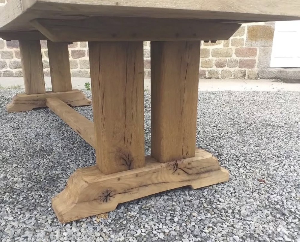 A three-metre long light oak farmhouse refectory table featuring a panelled top and a heavy trestle base. View II